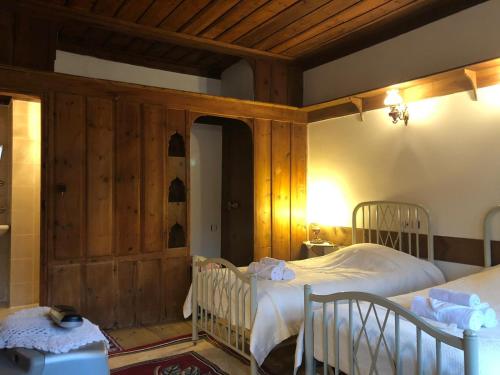 番红花城Paphlagonia Yoruk Muratoglu Konak的一间带两张床铺的卧室,位于带木墙的房间内