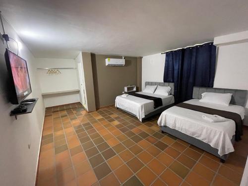 巴耶杜帕尔Hotel Valle Central的酒店客房设有两张床和一台平面电视。