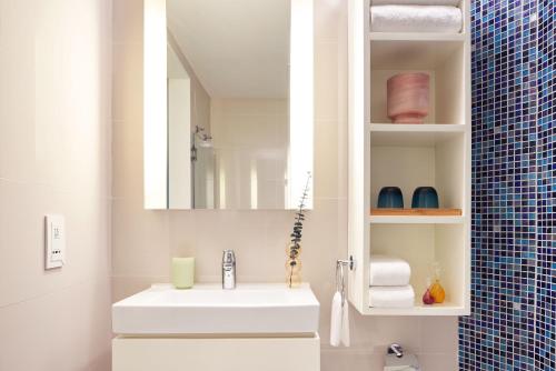 香港Ying'nFlo, Wesley Admiralty, Hong Kong的浴室设有白色水槽和镜子