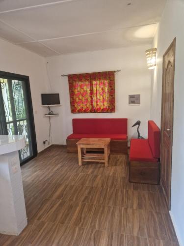 斯基灵角La Cazasamba的客厅配有红色的沙发和桌子