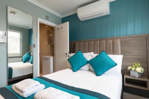 伦敦伦敦-维多利亚悉尼酒店的一间卧室拥有蓝色的墙壁,配有一张带蓝色枕头的床。