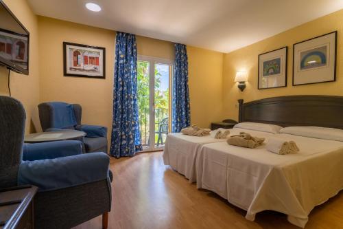 奇克拉纳－德拉弗龙特拉Hotel Balneario de Chiclana的酒店客房设有两张床和窗户。