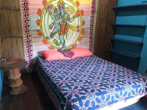 Santa ClaraFinca Bambú Del Valle的一间卧室配有一张带绘画的床铺