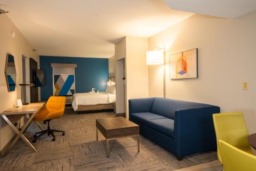 奥德马尔坦帕奥德马尔智选假日酒店及套房的酒店客房配有蓝色的沙发和床。