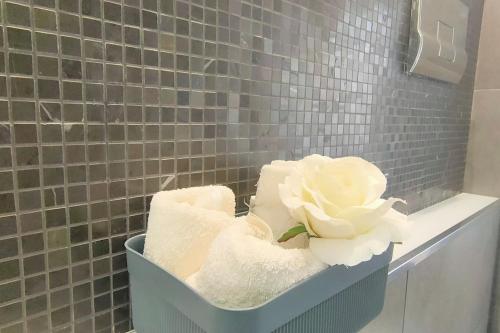 PietraperziaElegant house的浴室里备有一篮毛巾和一朵花