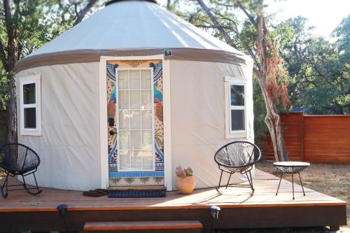 奥斯汀Camposanto Glamping - The Peacock Yurt的圆顶帐篷在甲板上配有桌椅