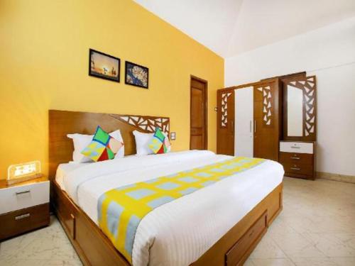 乌提Memmsta Hotels - 1587的一间卧室设有一张黄色墙壁的大床