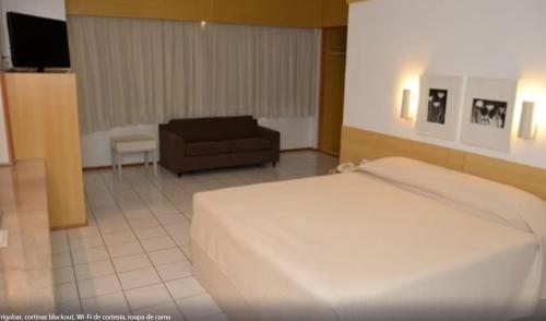 特雷西纳Rede Andrade Luxor的一间卧室配有一张床、一把椅子和一张沙发