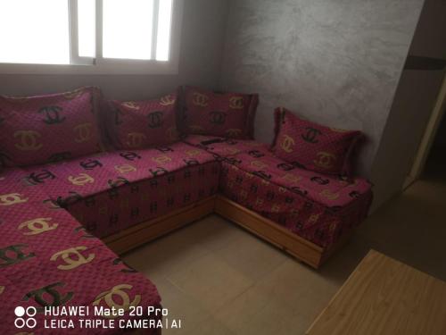 弗尼迪克Appartement à louer wadie的一张沙发,配有粉红色的床单和枕头