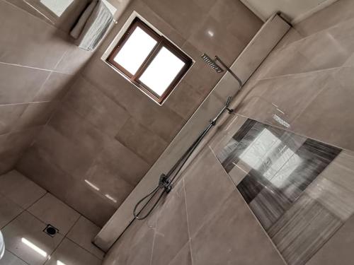 林贝Chambre de luxe chez FOUR IN ONE Résidence的带淋浴的浴室和窗户
