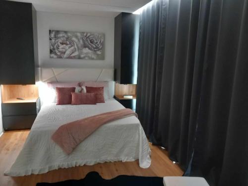 塞洛里库迪巴什图Casa de Silvares的一间卧室配有一张带红色枕头的大床