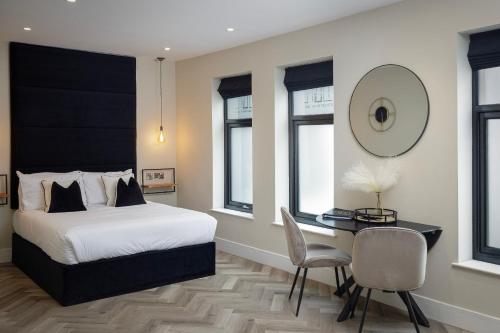 布莱克浦Five Apartments的一间卧室配有一张床和一张桌子及椅子