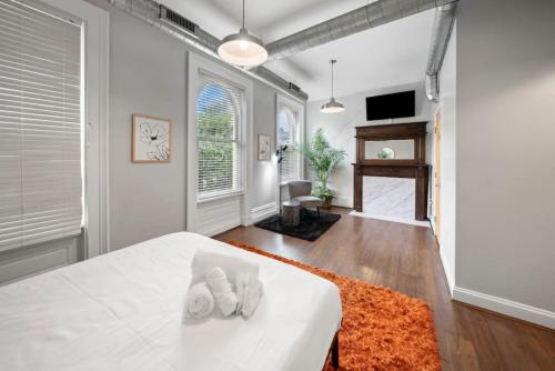 辛辛那提City Escape 2BR Steps to TQL near OTR and Downtown的一间卧室配有白色床单和橙色地毯。
