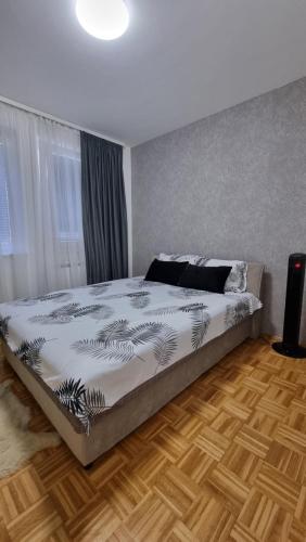萨拉热窝Aya apartment Sarajevo的一间卧室设有一张大床,铺有木地板