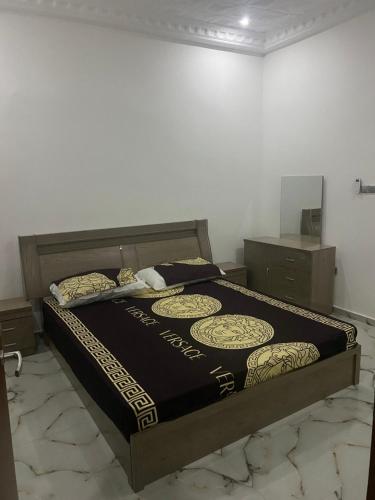 Sere KundaMarong Na kordaa的一间卧室配有一张带黑色和金色棉被的床