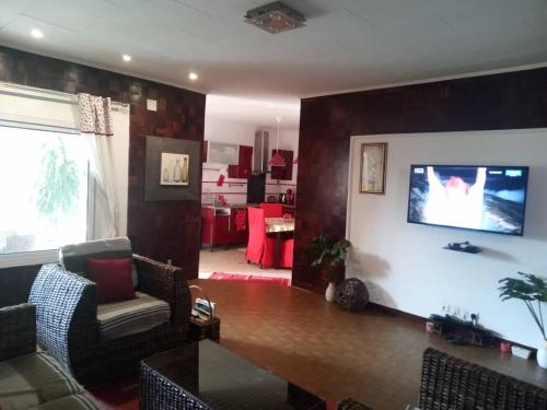 黑角Comme Chez Soi 1的客厅配有沙发和墙上的电视
