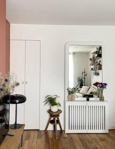 巴黎Charmant appartement parisien, spacieux & lumineux的一间设有镜子、桌子和凳子的房间