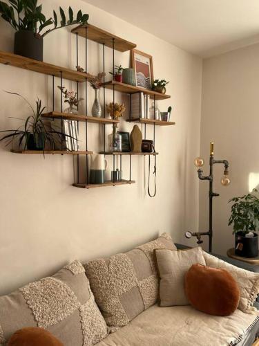 巴黎Charmant appartement parisien, spacieux & lumineux的客厅配有沙发和植物架子