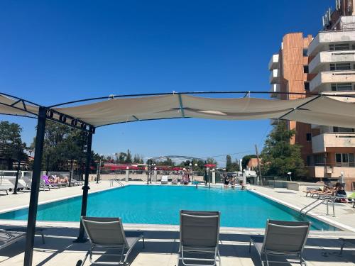 科斯蒂内什蒂Alessio Hotel Residence的一个带椅子和遮阳伞的游泳池