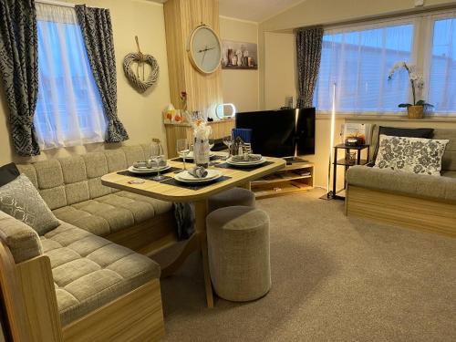Littlestone-on-SeaComfy Cosy Caravan_Romney Sands的客厅配有桌子和沙发
