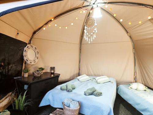 罗斯诺夫·波德·拉德霍斯滕Glamping Rožnov的帐篷内的一张床位,配有毛巾