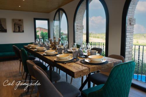卡尔多纳Cal Ganyada, Casa Rural Cardona的一张长桌,房间带椅子和窗户