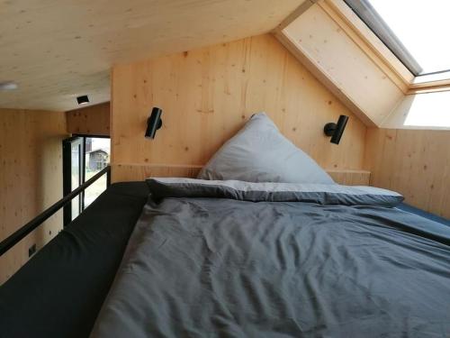 巴特武尔察赫Tiny House 1 im schönen Allgäu mit großem Garten, Naturnah的一个小房子中间的一张床位