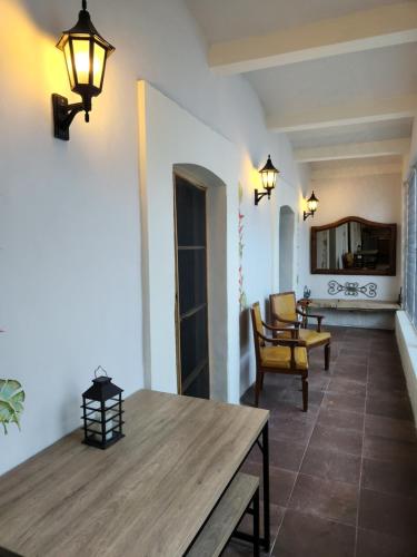 瓦哈卡市Hermosa Hacienda Las Heliconias的客厅配有木桌和椅子