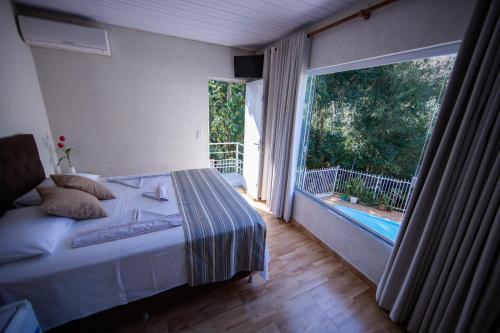 伊瓜苏Cachoeira dos pássaros的一间卧室设有一张床和一个大窗户