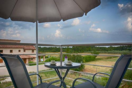 罗波里卡Apartment Vacation Rental Near Pula的庭院配有桌椅和遮阳伞。