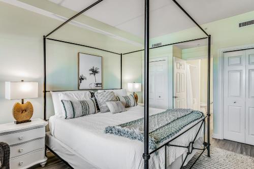 沃尔顿堡滩Pelican Isle 606的一间卧室配有一张带镜子的天蓬床