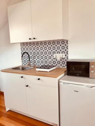 坎巴多斯Apartamento estudio en Cambados Fefiñanes的白色的厨房配有水槽和微波炉
