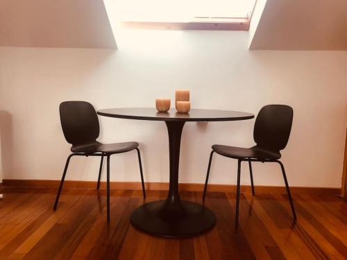 坎巴多斯Apartamento estudio en Cambados Fefiñanes的一张桌子,上面有两把椅子和两把蜡烛