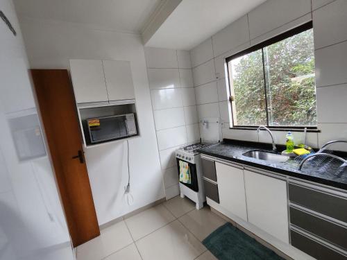 多拉杜斯DOURADOS GUEST FLAT PEDRA BONITA的一个带水槽和窗户的小厨房