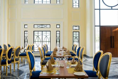 巴哈瓦尔布尔Falettis Grand Bahawalpur的用餐室设有桌椅和窗户。