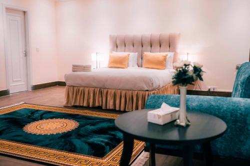 巴哈瓦尔布尔Falettis Grand Bahawalpur的一间卧室配有一张床、一张桌子和一张沙发