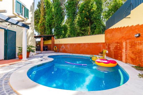 奥埃拉斯Jacuzzi, garden, pool & barbecue beach House, 15mn from Lisbon center的后院的游泳池,有充气木筏
