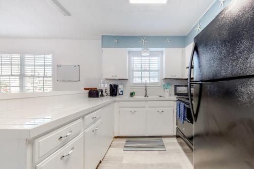 南帕诸岛Lazy Seagull Beach House的厨房配有白色橱柜和不锈钢冰箱