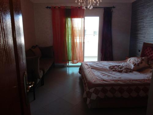 Douar OurlaliChez Mostafa的一间卧室设有床、窗户和沙发