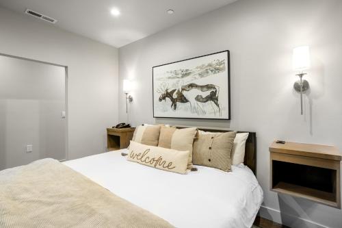 范尔Lion Square Lodge South 255, 257 & 261的白色卧室设有一张大床,墙上挂着一张照片