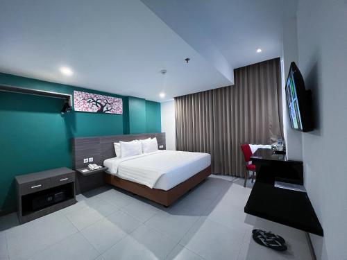 班达亚齐班达亚齐艾亚尼酒店的一间卧室配有一张床和一台电视