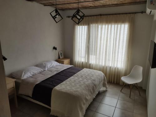 圣罗莎Los Deptos de Alvear的卧室配有床、椅子和窗户。