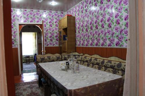 卡拉科尔Guest House on Derbisheva的一间用餐室,配有一张桌子和紫色壁纸