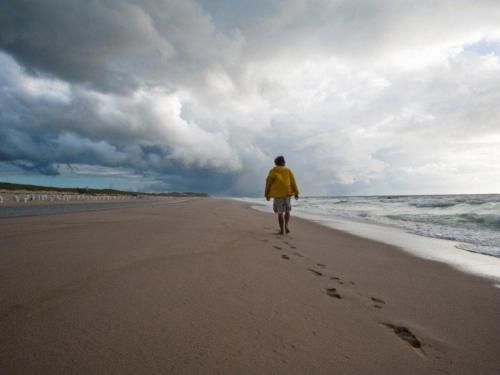 坎彭Spatzennest的一个人在沙滩上行走,脚印在沙滩上