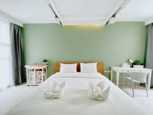 清迈SherVa101 Home and Hostel的一间卧室,床上有两朵白色的花