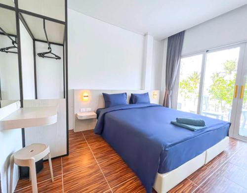 芭东海滩88 House Patong的一间卧室配有蓝色的床和一张书桌