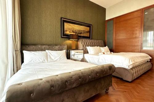 丹绒道光Cozy Straits Quay Seafront Suite的一间卧室配有两张床和一张沙发。