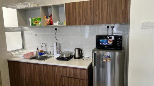 伯恩仓Sweet Homestay 3RM @ Penthouse Apartment in Brinchang的厨房配有不锈钢冰箱和水槽
