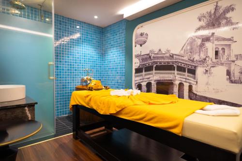 会安Bel Marina Hoi An Resort的卧室配有一张黄色的床,墙上挂着一幅画