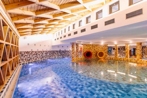索瓦塔HOTEL CRYSTAL WELLNESS & SPA superior的一座带木制天花板的大型建筑中的游泳池